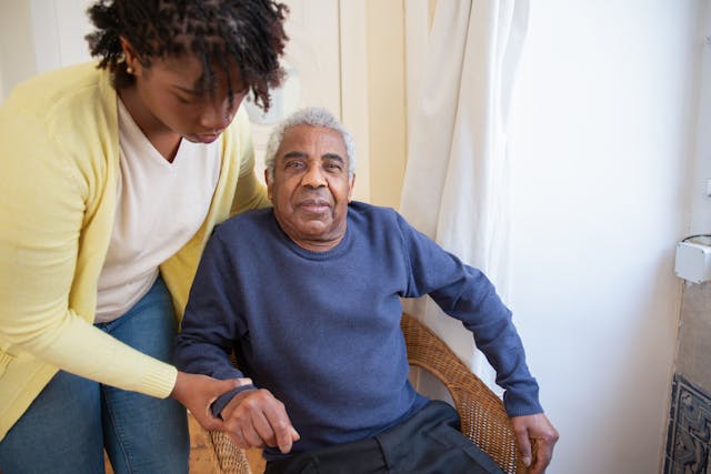 resident being helped out of chair