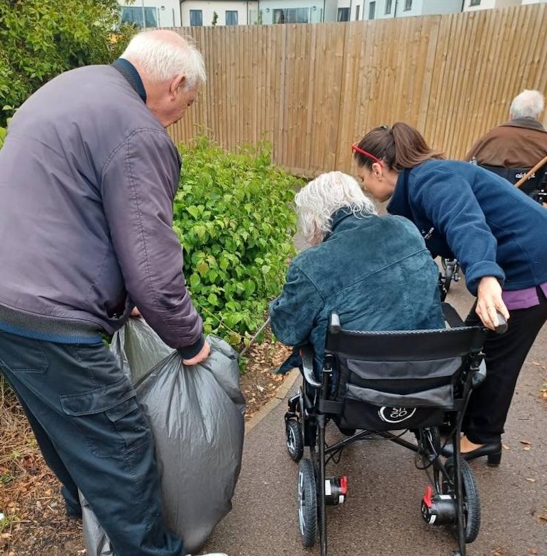 resident out in the garden picking up rubbish