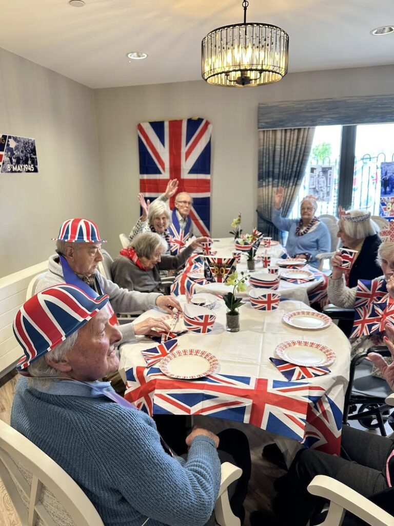 residents sat around a table eating and celebrating