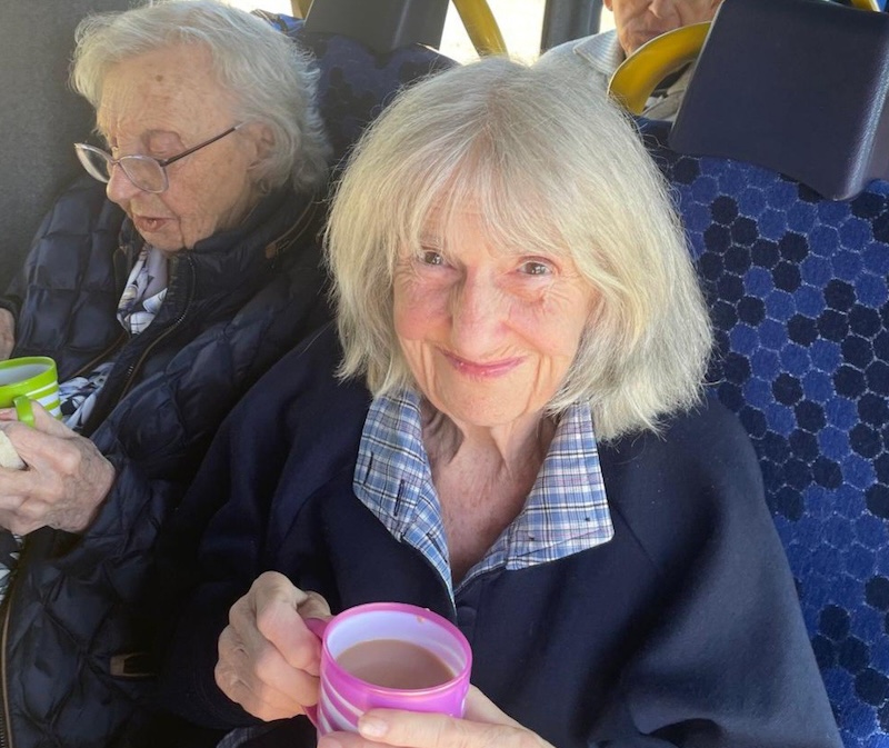 resident in minibus with a hot drink