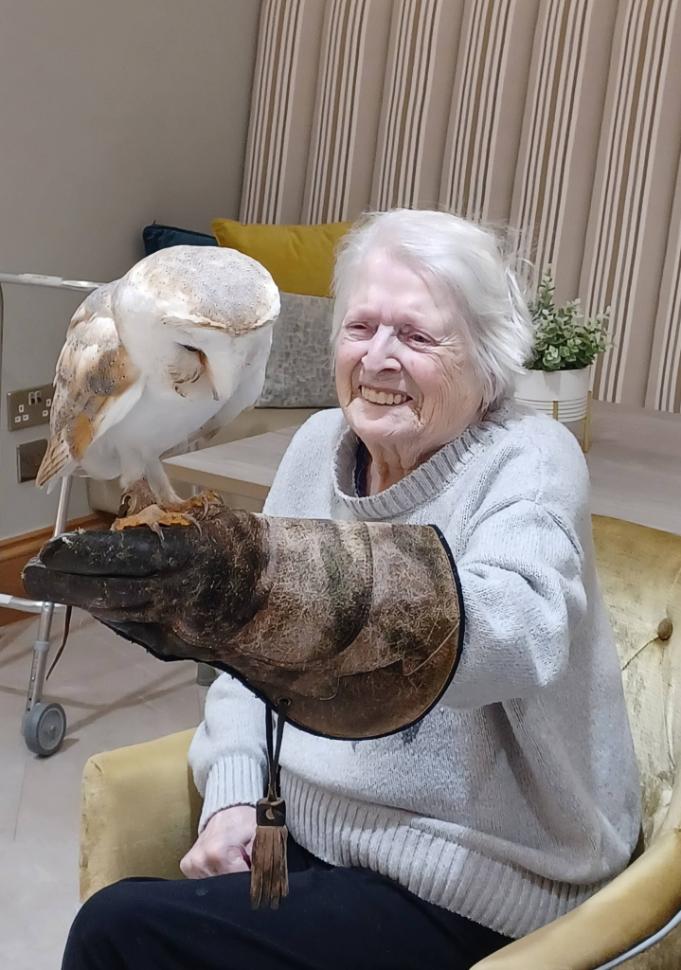 resident with an owl on her arm