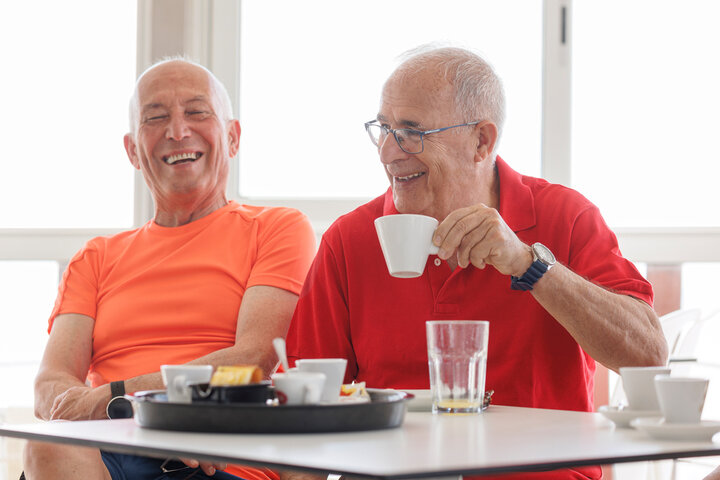 two men laughing with a cup of tea
